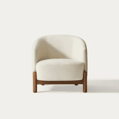 A modern armchair upholstered in a textured, light-colored fabric. It features a gently curved backrest that extends to armrests. The chair is supported by a dark wood frame with distinct legs that are cylindrical at the bottom and square where they meet the seat. — 3D model