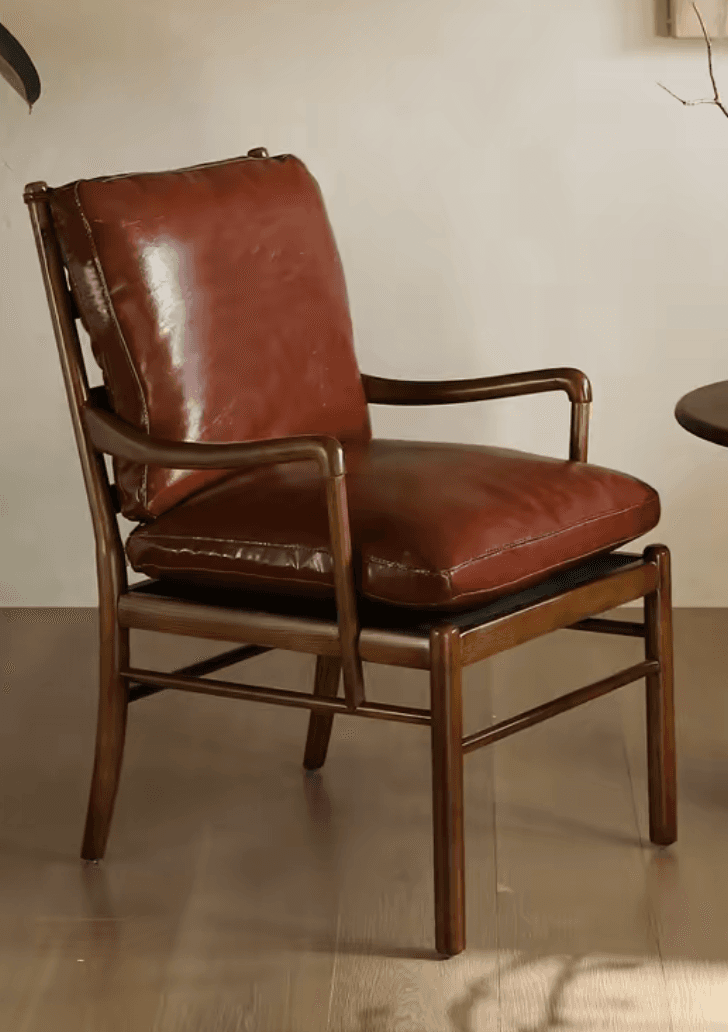 A robust armchair featuring a visible wooden frame and plush, brown leather cushions on the seat and back. — 3D model