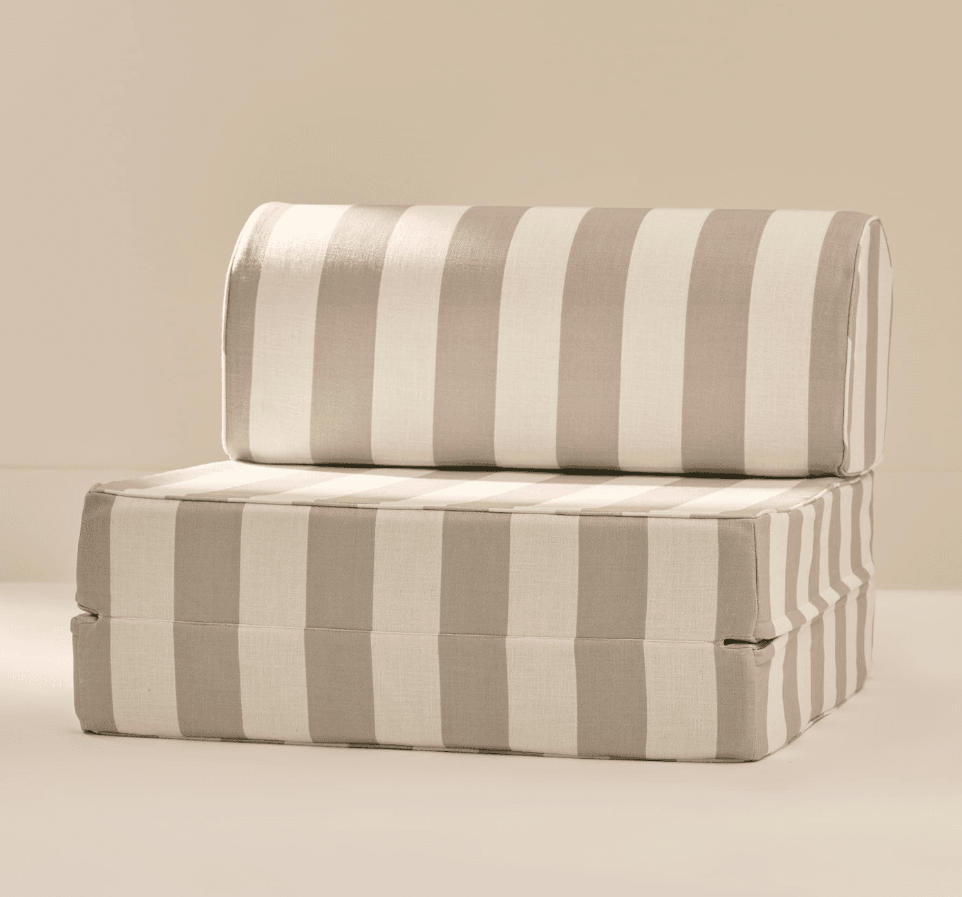 A striped sofa bed in a folded configuration. The item has a cushioned seat and backrest, both upholstered in fabric with alternating wide vertical stripes of off-white and a light taupe color. The seat section appears to be composed of two stacked cushions, suggesting a folding mechanism. The backrest is a cylindrical shape and rests on top of the seat. The overall form is boxy with rounded edges on the backrest. — 3D model