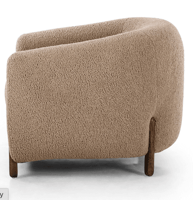 A contemporary, fully upholstered lounge chair with a rounded, organic form, covered in a textured, light beige boucle fabric and supported by short, dark cylindrical wooden legs. — 3D model