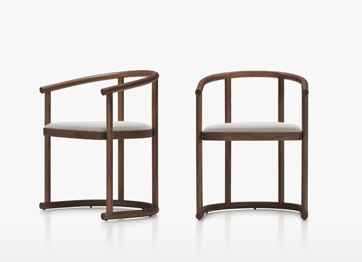 Two armchairs with curved wooden frames and upholstered seats. The frame consists of vertical legs, horizontal stretchers, and a continuous curved armrest that extends from the back to the front. The seat is low and rectangular, upholstered in a light-colored fabric. — 3D model
