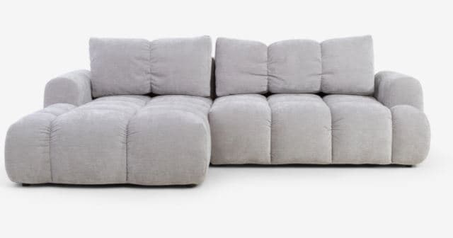 A modern modular sectional sofa upholstered in light grey fabric, featuring deep, plush, segmented cushions for the seat, back, and arms, with a distinct chaise lounge extension on one side. — 3D model
