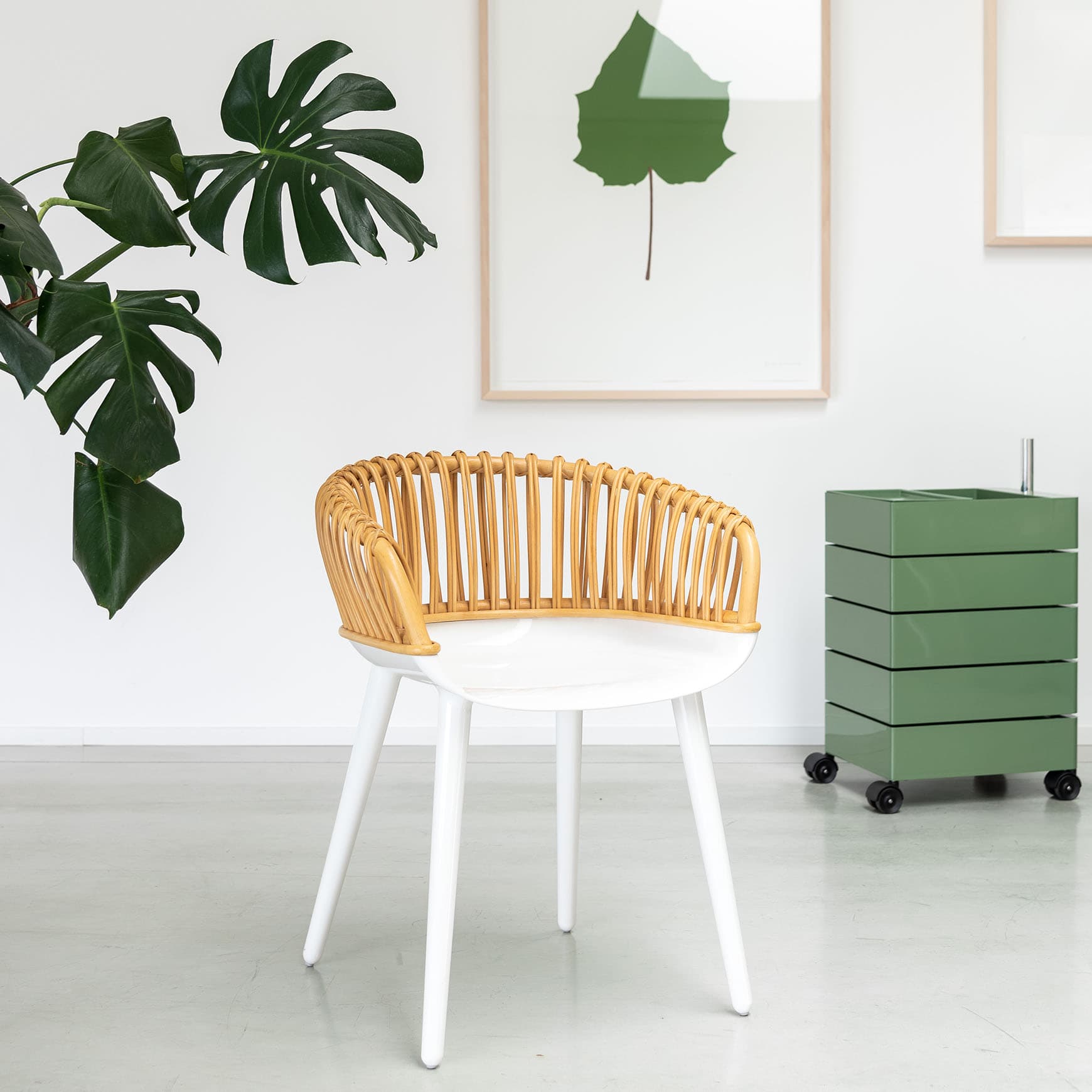 A modern accent chair featuring a curved, slatted rattan backrest and integrated armrests, a smooth white molded seat, and four splayed white legs. — 3D model