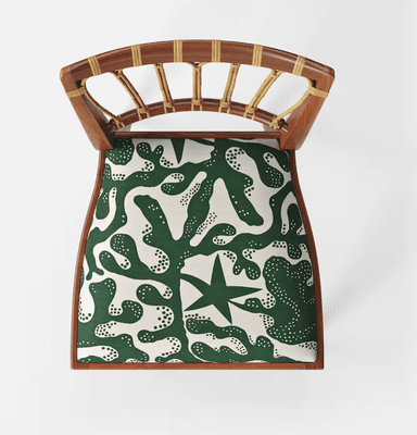 A wooden chair with a curved backrest featuring vertical, cane-wrapped spindles and a padded seat upholstered in a green fabric with a white abstract pattern. The chair has a solid wooden frame with four tapered legs. — 3D model