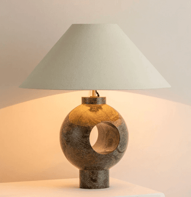A table lamp with a conical shade and a spherical base. The base is made of a polished stone with varied earthy tones and veining, featuring a circular cut-out. The shade is a neutral cream color and appears to be made of fabric. — 3D model