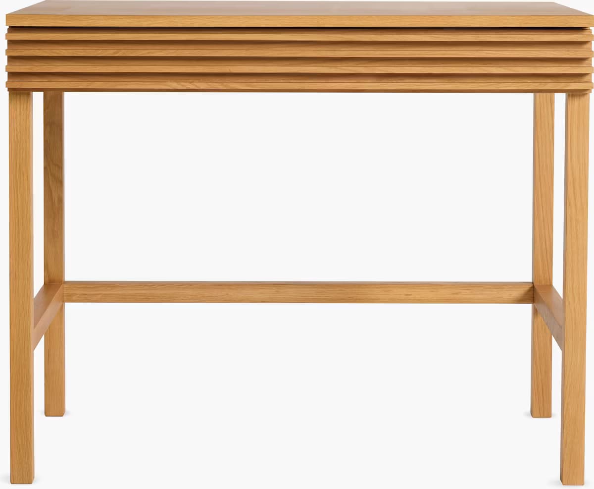 A light-colored oak wood desk featuring a distinct slatted drawer front and a minimalist design. The desk stands on four sturdy legs connected by horizontal stretchers for added stability. — 3D model
