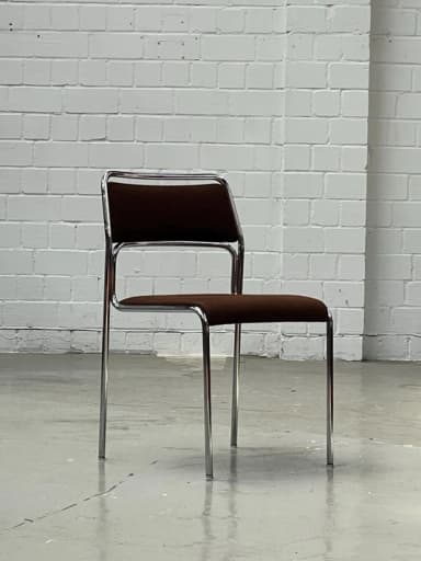 An armless side chair featuring a polished chrome tubular metal frame with a dark brown upholstered seat and backrest. The chair is presented against a plain white background. — 3D model