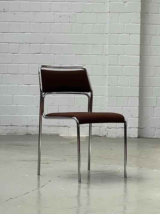 An armless side chair featuring a polished chrome tubular metal frame with a dark brown upholstered seat and backrest. The chair is presented against a plain white background. — 3D model