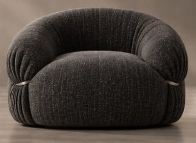 A contemporary, generously padded armchair with a sculptural and organic form, upholstered in a dark charcoal grey fabric with subtle white flecks. The chair features a rounded, low-slung profile and distinct pleating or gathering of the fabric, particularly evident around the armrests and base, giving it a plush, cloud-like appearance. A single, sleek silver-toned metal ring acts as a decorative and structural detail on one side, cinching the upholstery. — 3D model