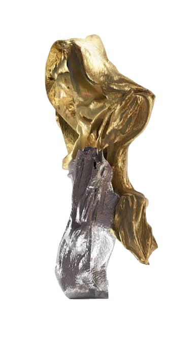 An abstract, modern sculpture featuring an organic, flowing form. It is composed of two distinct metallic elements: an upper section with a rich, textured gold finish and a lower section with a contrasting silver finish. The surface exhibits a highly textured, almost molten or draped quality, creating visual depth and movement. The sculpture stands upright on a subtle base, showcasing a dynamic interplay between its two-tone metallic surfaces. — 3D model