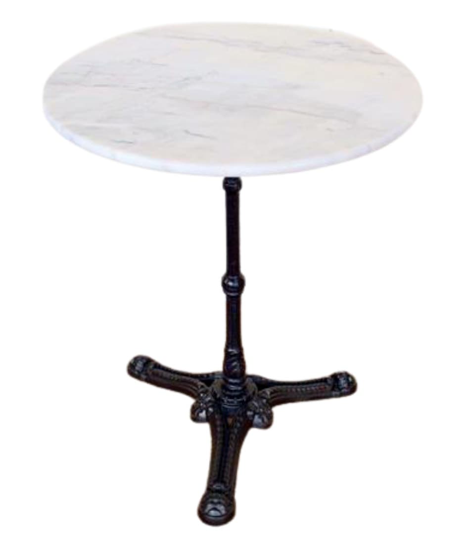 A round bistro table featuring a white marble top with subtle grey veining, supported by a single, dark-colored, ornately cast iron pedestal base. The base has four scrolling feet for stability and decorative elements on the column. — 3D model