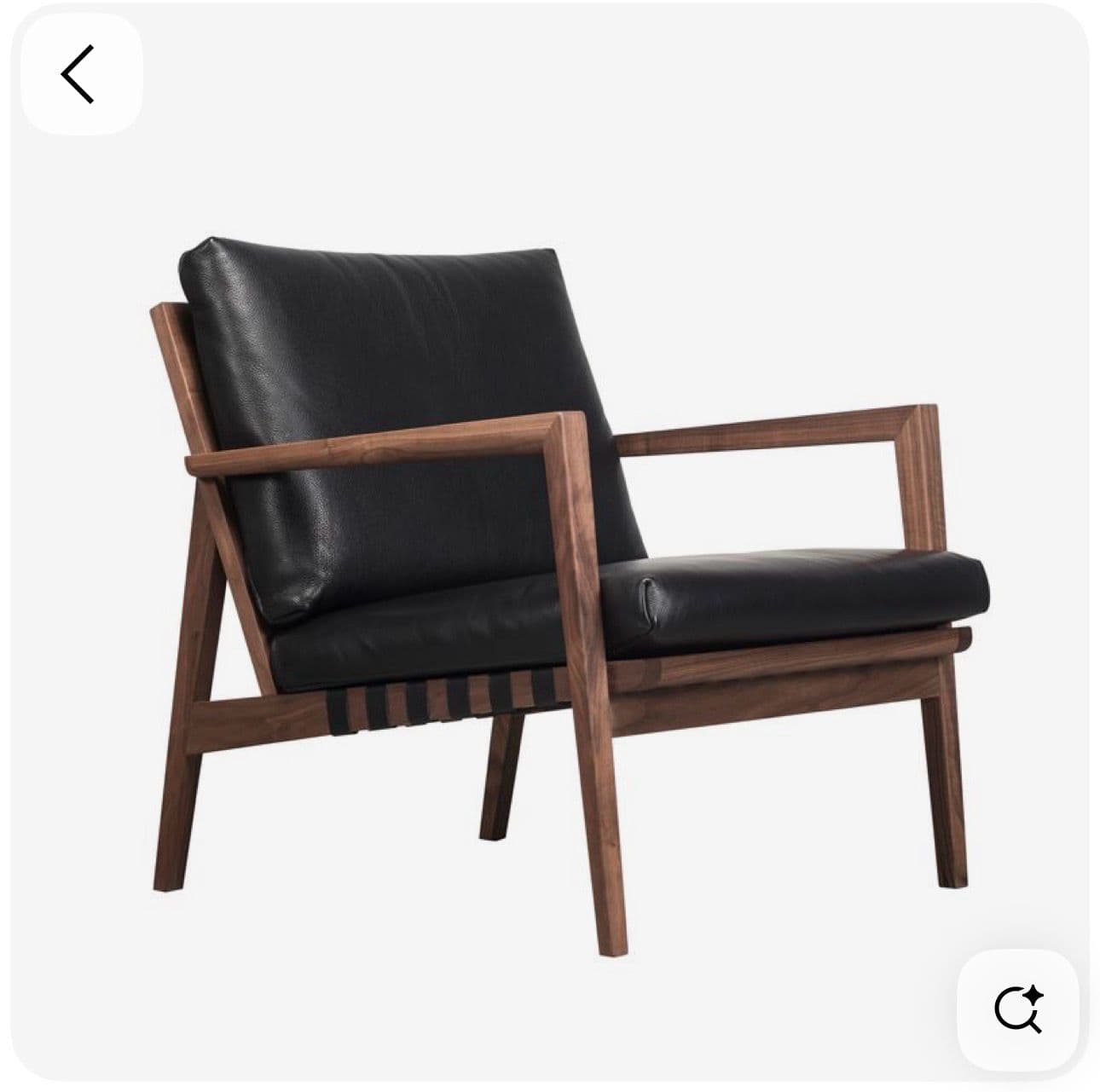 A stylish armchair featuring an exposed dark wood frame, likely walnut, and plush black leather seat and back cushions. The design exhibits clean lines and a minimalist aesthetic with visible support webbing under the seat. — 3D model