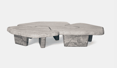 A low-profile coffee table with an organic, irregular shape. The tabletop is segmented into three distinct, curved sections that appear to interlock or flow into one another. The table is supported by four block-like legs of varying heights, also exhibiting an organic, asymmetrical form. The overall design is sculptural and abstract. — 3D model