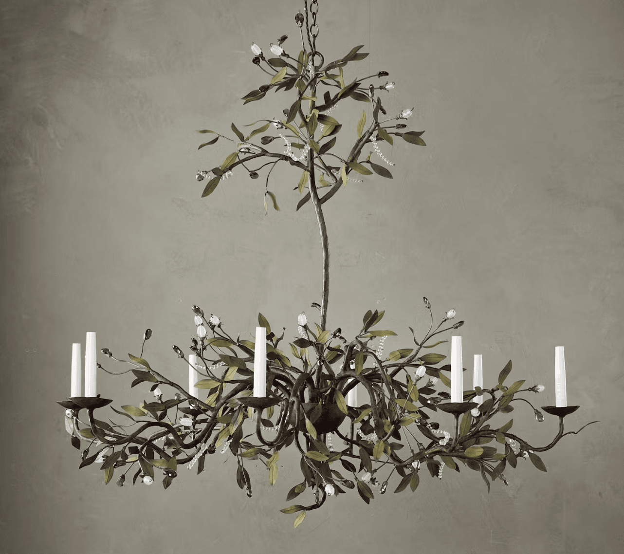 A multi-tiered chandelier designed to resemble a tree or vine, featuring metal branches adorned with green leaf-shaped elements, clear crystal beads, and small bud-like embellishments. It has multiple candle-style light fixtures with white candle covers. The central stem and branches are dark, possibly bronze or iron, with a somewhat rustic finish. The overall design evokes a natural, organic aesthetic. — 3D model