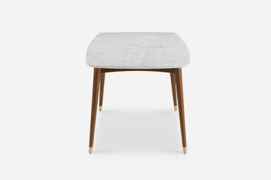 A rectangular dining table with a marble top and wooden legs. The marble top features a white base with grey veining, and its edges are rounded. The table has four tapered legs made of dark wood, each capped with a brass accent at the bottom. A wooden frame connects the legs beneath the tabletop. — 3D model