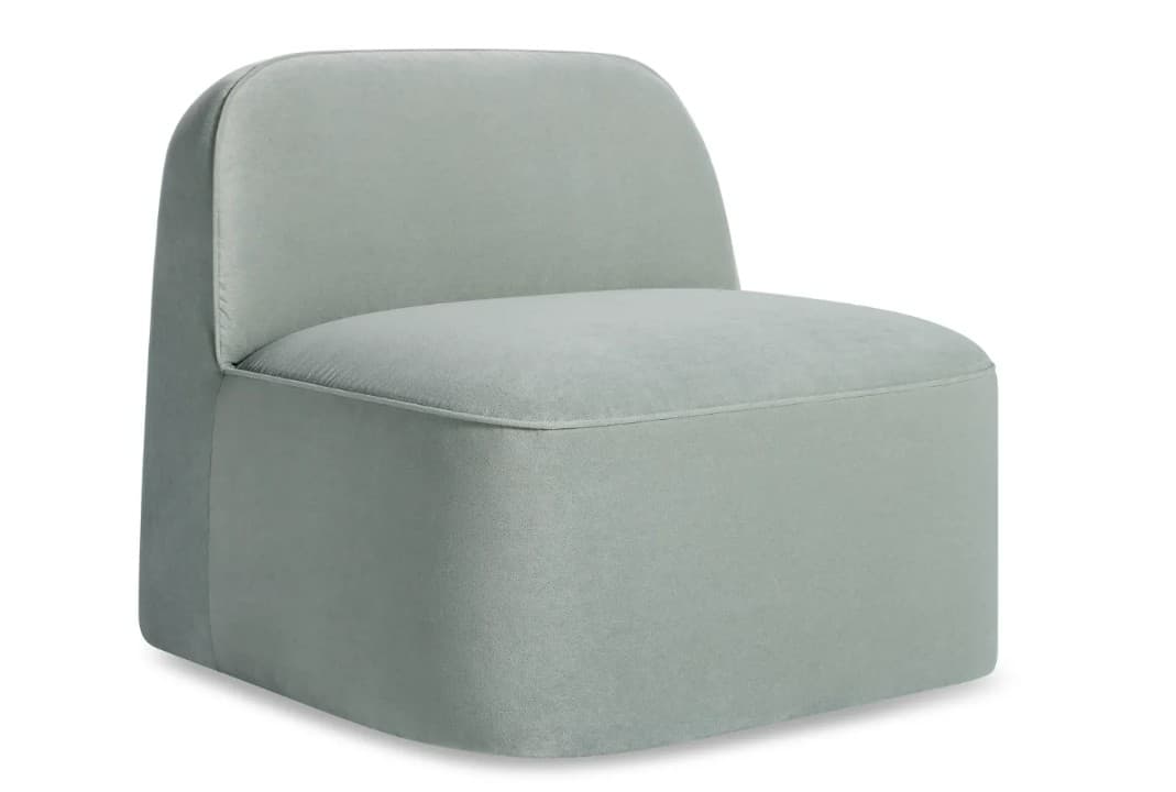 A single-seater armchair with a low profile and a rounded backrest. The upholstery appears to be a soft fabric, with visible stitching along the edges of the seat and back. — 3D model