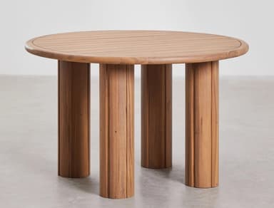 A round wooden coffee table with four thick, cylindrical legs. The tabletop has a slatted surface and a rounded edge. The legs are textured with vertical grooves. The design appears to be modern or contemporary, possibly intended for outdoor use due to the material. — 3D model
