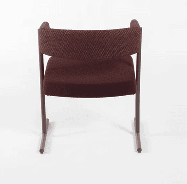 A modern upholstered armchair featuring a distinctive curved backrest that seamlessly transitions into armrests. The chair is supported by a minimalist dark brown metal sled base, giving it a contemporary floating appearance. The seat and backrest are covered in a rich maroon or burgundy-colored textured fabric, possibly bouclé, providing both comfort and visual interest. The design is clean and architectural, emphasizing form and material. — 3D model