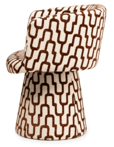 A modern armchair with a rounded, upholstered form. The chair features a high back that curves into armrests, enclosing the seating area. The base is a tapered pedestal, also upholstered, providing stability. The upholstery displays a geometric pattern of interlocking U-shapes in brown on an off-white background. — 3D model