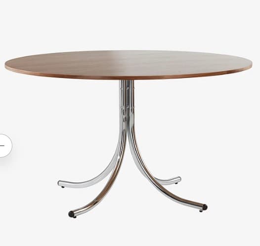 A round wooden table with a chrome pedestal base, featuring four curved, splayed legs. — 3D model