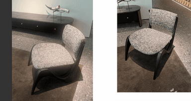 An armless dining chair featuring a distinctive dark, possibly ebonized wood frame with sculptural, curved legs and a gently curved backrest. The seat and backrest are upholstered in a light grey, textured fabric. — 3D model