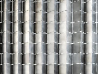 A room divider composed of multiple square, metallic panels arranged in a flexible, accordion-like structure. The panels are connected by visible fasteners, allowing them to fold and pivot. The surface reflects light, creating a shimmering, alternating pattern of light and dark squares. — 3D model