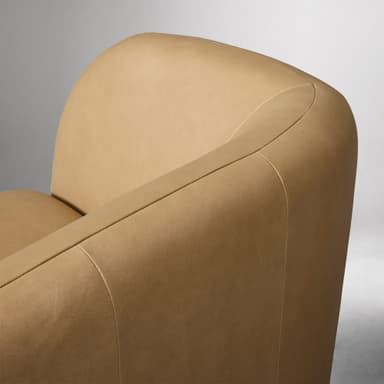 A contemporary two-seater loveseat upholstered in tan leather with a curved back and integrated armrests, resting on a dark wooden plinth base. — 3D model