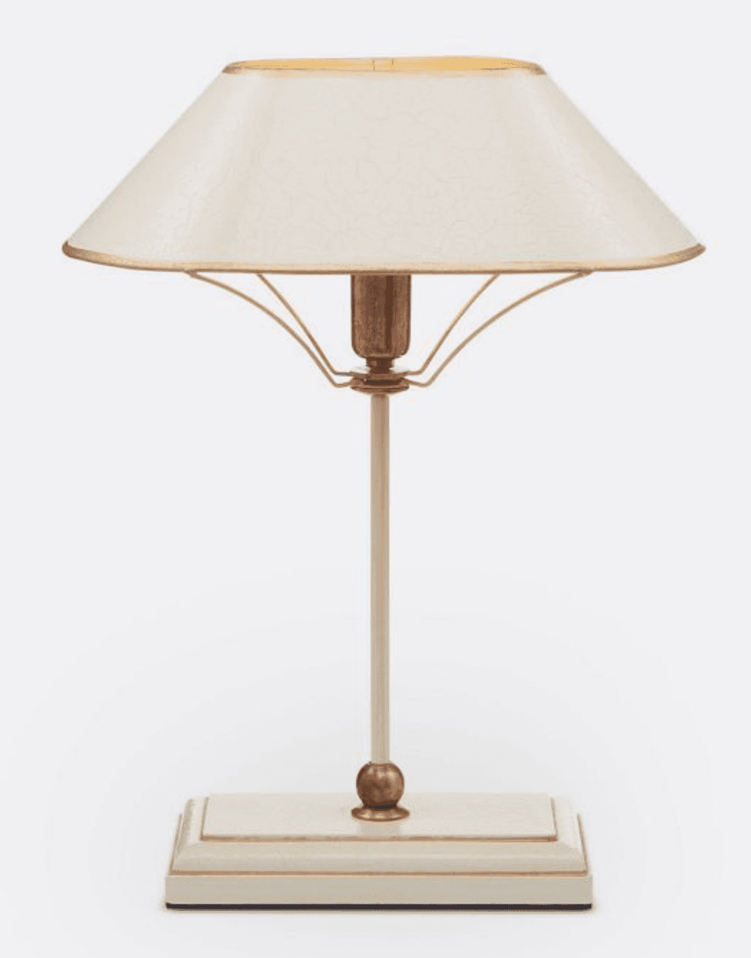A table lamp with a rectangular base, a slender central stem, and a conical lampshade. The base and stem are a light cream color, with gold accents on the edges of the base and a small spherical ornament at the base of the stem. The lampshade is also cream-colored with a subtle textured pattern and a thin gold trim along its top and bottom edges. The internal structure supporting the lampshade appears to be gold-toned metal. — 3D model
