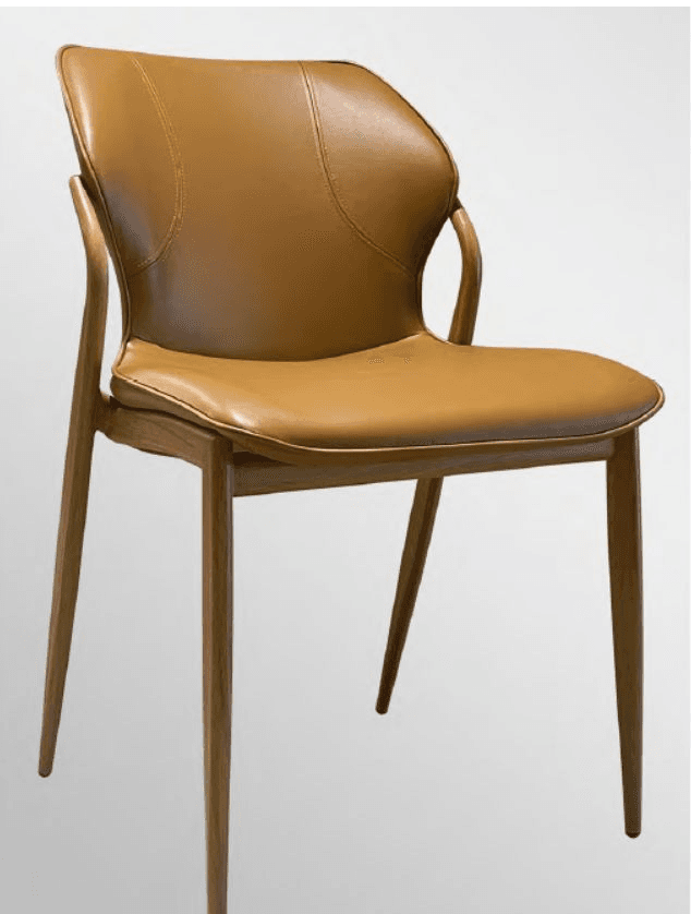 A contemporary dining armchair featuring a slender wooden frame with integrated armrests and upholstered seat and back. The upholstery is a smooth, caramel-colored material, likely faux leather, with subtle saddle stitching details on the backrest. The four legs are tapered and splayed slightly for stability and aesthetic appeal. The overall design suggests a modern or mid-century inspired aesthetic suitable for dining or accent use. — 3D model