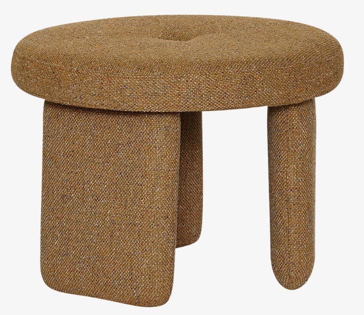 A small, round, fabric upholstered ottoman featuring a single button tuft on its top surface. It is supported by three short, thick, and rounded legs, all covered in a textured, woven brownish-gold fabric. — 3D model