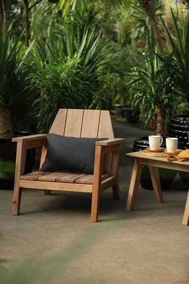 A wooden armchair with a slatted seat and back, featuring a dark grey cushion. The chair has a robust construction with visible wood grain and a natural finish. — 3D model