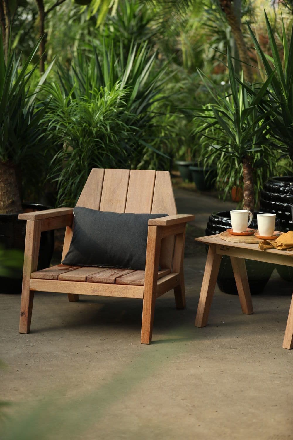 A wooden armchair with a slatted seat and back, featuring a dark grey cushion. The chair has a robust construction with visible wood grain and a natural finish. — 3D model