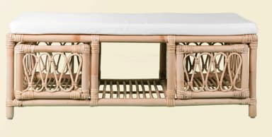 A long, rectangular bench featuring a natural rattan and bamboo frame, topped with a white fabric cushion. The base of the bench is divided into two sections, each with an open storage compartment accessible from the front, defined by woven rattan detailing and a slatted shelf. — 3D model