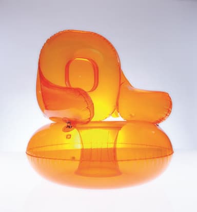 An orange, translucent inflatable armchair resembling a balloon. It has a rounded seat and a curved backrest. The surface shows creases and reflections, indicative of an inflated material. A valve is visible on the seat cushion. — 3D model
