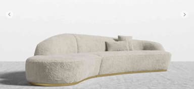 A modern curved sectional sofa upholstered in light bouclé fabric with a recessed gold-finished plinth base, designed for contemporary living spaces. — 3D model