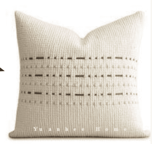 A square-shaped decorative throw pillow featuring a textured knitted pattern. The pillow is off-white or light beige with horizontal rows of dark gray, dashed accents interspersed within the knitted fabric, creating a subtle geometric design. The knitted texture appears soft and plush, and the pillow is shown at an angle, highlighting its plump form. — 3D model