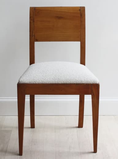 A wooden chair with a curved backrest and a upholstered seat. The chair has four legs, with the front legs tapering towards the floor and the back legs having a subtle curve. — 3D model