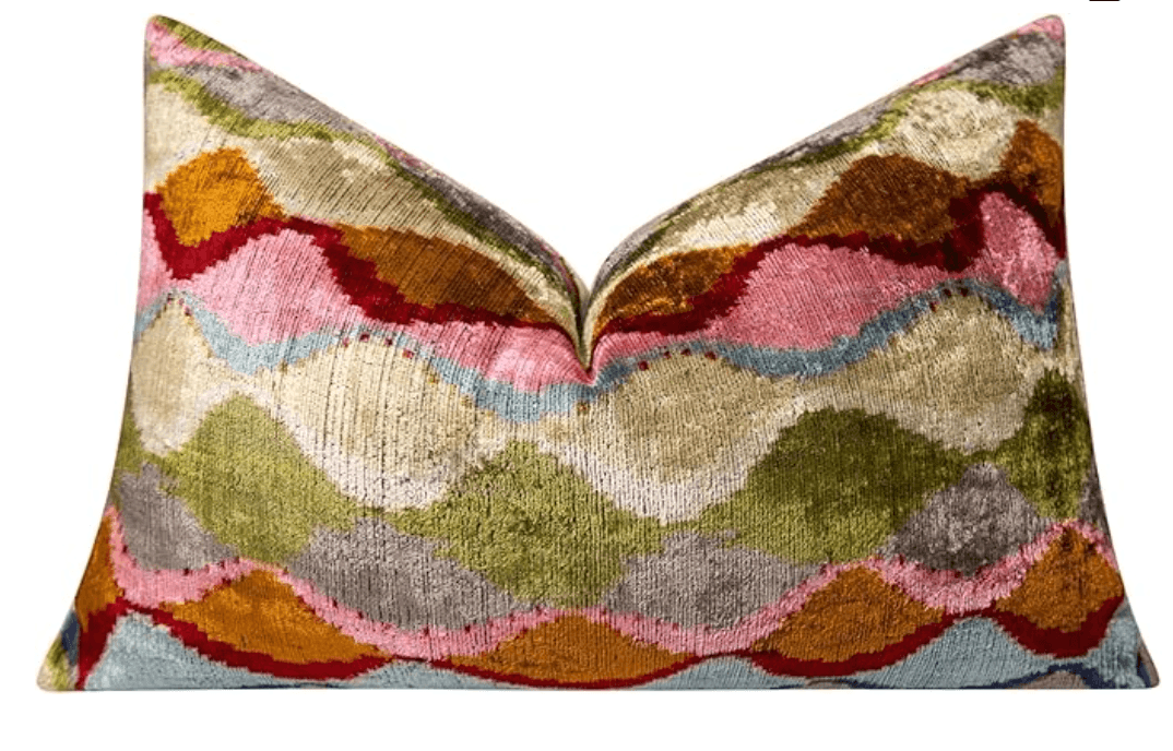 A decorative pillow with a wave-like pattern featuring multiple colors and textures. The pillow appears to be filled and plump, with a visible seam at the top where the fabric is gathered, creating a pinch point. — 3D model