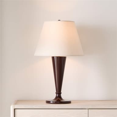 A table lamp featuring a dark brown, possibly lacquered, tapered base resting on a circular foot, topped with a cream-colored conical fabric shade. — 3D model