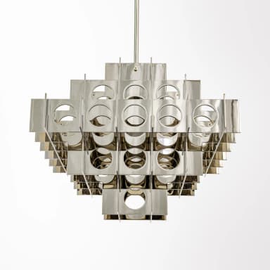 A modern chandelier featuring a modular, geometric design. The fixture is constructed from numerous rectangular and triangular metal elements arranged in overlapping layers, creating a complex, three-dimensional lattice structure. Circular cutouts are present within some of the rectangular panels, allowing light to pass through. The reflective surface gives it a metallic sheen. — 3D model