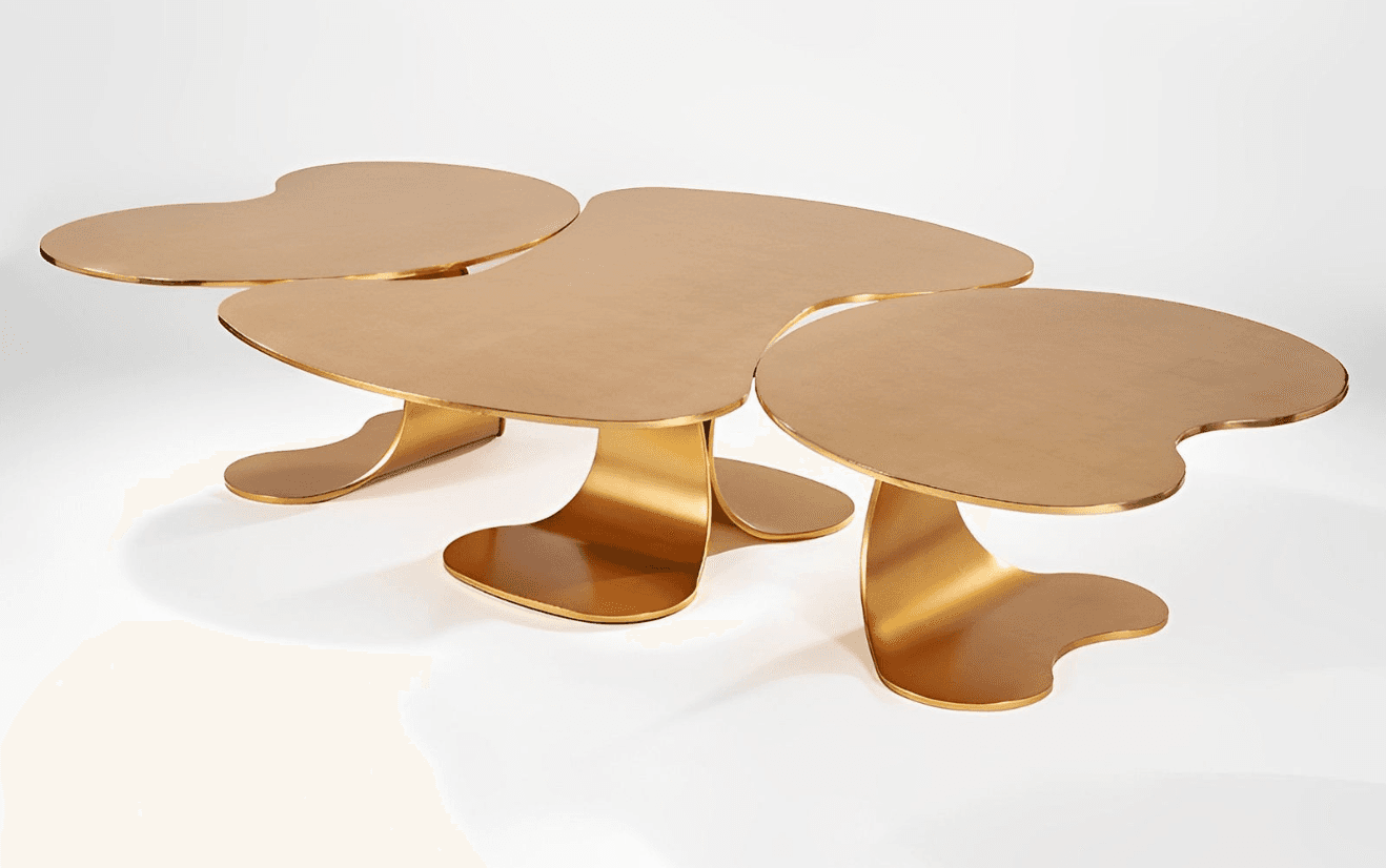 A contemporary coffee table with a unique, organic design. It features multiple, interconnected leaf-like or amoeba-shaped tabletops supported by sculptural bases. The overall form suggests a modular or fluid arrangement. — 3D model