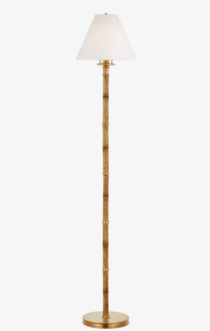 A tall floor lamp featuring a slender, textured stalk designed to mimic bamboo, with polished brass accents and a circular base. It is topped with a classic white fabric empire shade. — 3D model