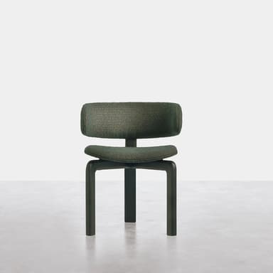 A modern armless chair featuring a low, plush, dark green bouclé-textured upholstered backrest and seat, separated by a distinct gap. The chair is supported by a sturdy, dark, minimalist H-shaped frame that also forms its four block-like legs. The design emphasizes clean lines and a compact footprint. — 3D model
