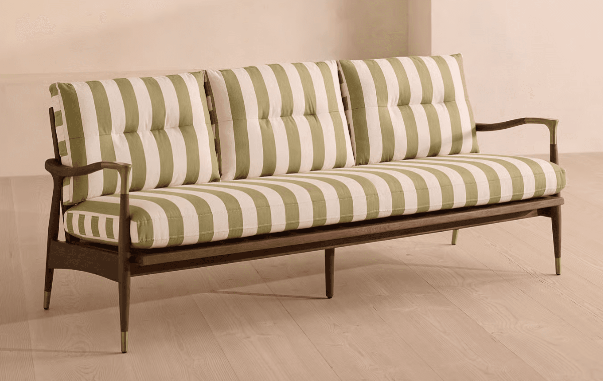 A contemporary three-seater sofa featuring a distinctive exposed dark wood frame, light olive green and off-white striped upholstery, and brass accents. The sofa has a linear silhouette with subtly curved wooden armrests, button-tufted back cushions, and tapered legs tipped with brass ferrules. — 3D model