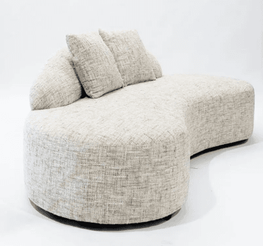 A modern, upholstered sofa with a distinctive curved silhouette. It features a low profile and a flowing, organic shape. The sofa is covered in a textured, neutral-toned fabric and includes two matching throw pillows. The base appears to be dark and slightly recessed. — 3D model