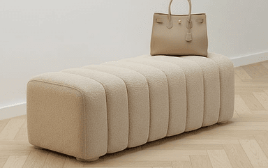 A long, rectangular upholstered bench featuring a channel-tufted design. It is covered in a light beige, textured boucle-like fabric and supported by low, discreet feet. — 3D model