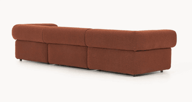 A three-piece modular sectional sofa upholstered in a reddish-brown, textured bouclé fabric. The sofa features a low profile with soft, rounded edges and integrated armrests that curve over the sides. It consists of two end modules with armrests and one armless middle module, allowing for flexible configuration. Small, dark, recessed feet are visible at the base. — 3D model