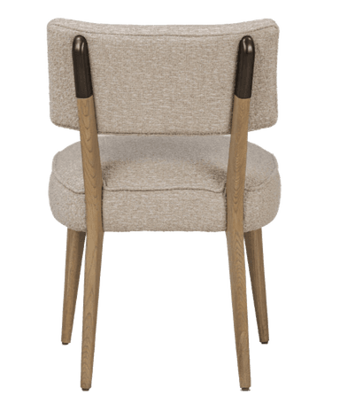 A view of the back of a upholstered armchair. The chair features a curved backrest and a cushioned seat. The legs and armrest accents are made of wood. The upholstery appears to be a textured, light-colored fabric. — 3D model