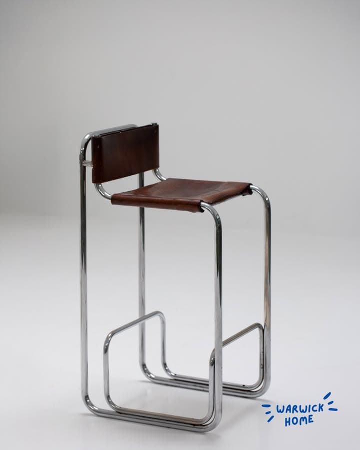 A high-seated bar stool featuring a continuous frame constructed from bent tubular chrome and a seat and backrest upholstered in brown leather, exhibiting a minimalist, modernist aesthetic. — 3D model
