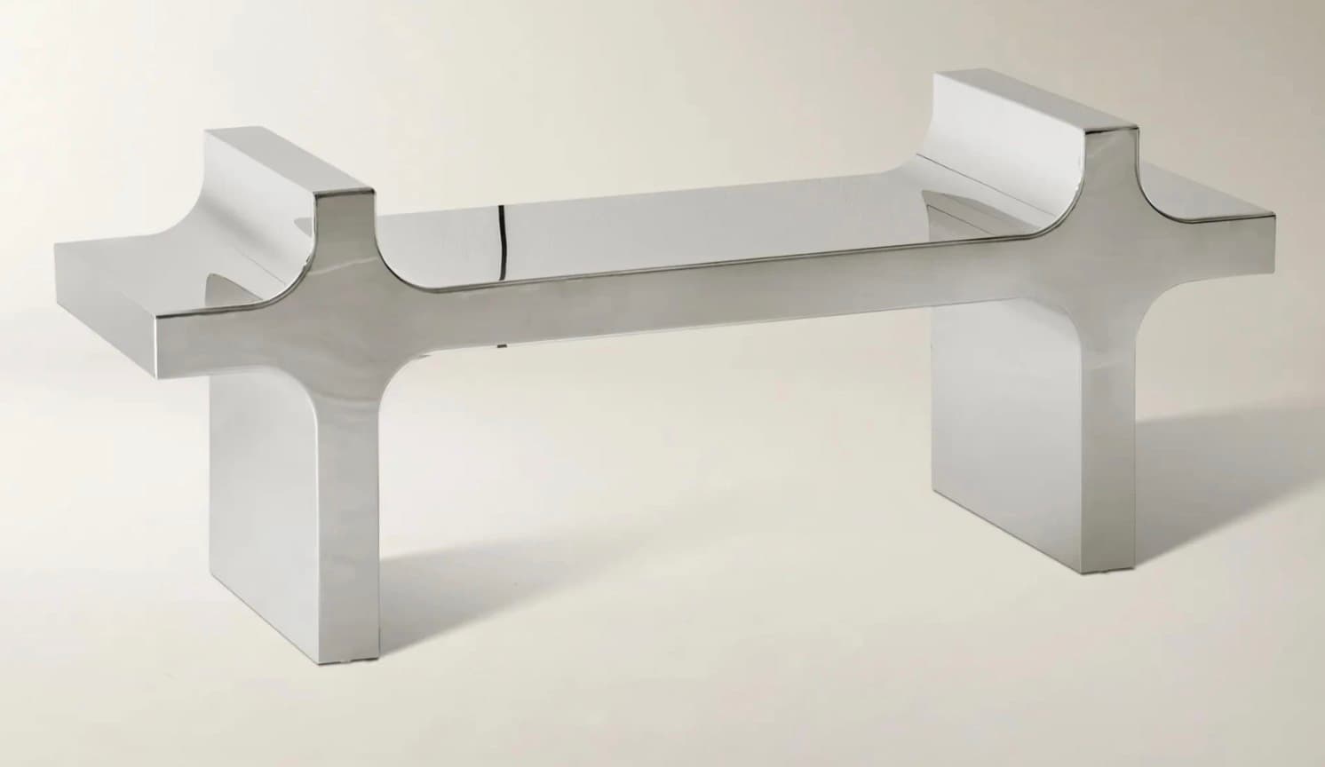 A modern coffee table with a striking silhouette. It features two substantial, geometric legs with curved upper sections, connected by a central, elongated horizontal element. The design is minimalist and sculptural, with a highly reflective surface. — 3D model